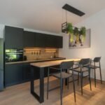 bdm6 - Panama Sport Fishing Charters Modern kitchen with black cabinets, stainless fridge, and a wooden island with four bar stools.