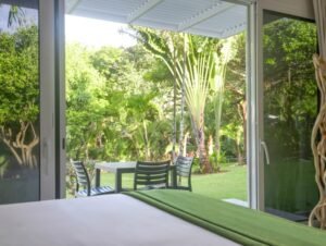 - Panama Sport Fishing Charters Open sliding doors reveal a sunny backyard with a white table and black chairs on the lawn.