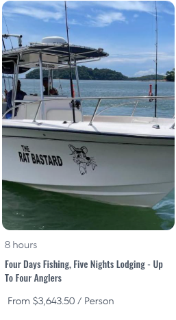 4D5L - Panama Sport Fishing Charters Motorboat named The Rat Bastard with a cartoon rat logo, docked on calm water with a coastal hills landscape in the background.